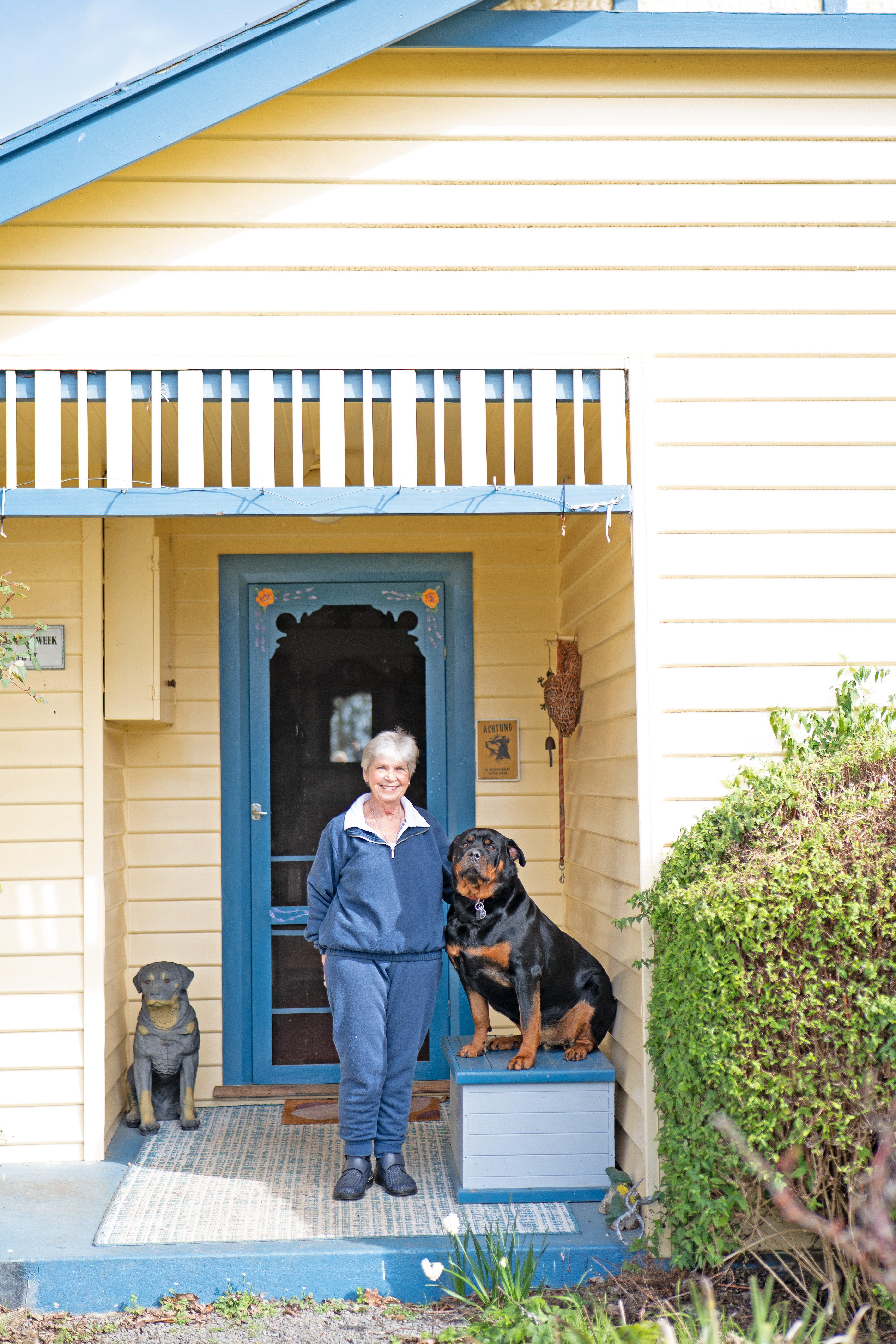 A woman and her dog outside her weatherboard home