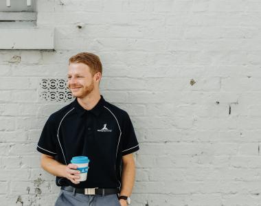 Aurora Energy Employee (male) leaning against a wall