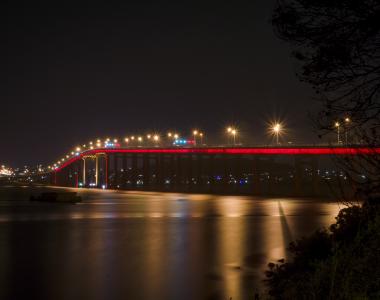 image of the Tasman Bridge at night time, lit up with red lights for Dark Mofo
